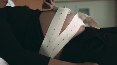 Doğum öncesi anlarda fetal kalp ritmi kayışları annenin karnına bağlı.