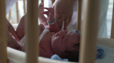 Anneler yeni doğan bebek kıyafetlerini beşiğinde dikkatlice ayarlar, beşik barlarından bakar, doğum sonrası ilk anlarda gösterilen şefkatli ve sevgi dolu ilgiyi vurgular, annelik sevgisini vurgular. 