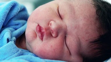 Doğumdan sonra hayatın ilk günü uyuyan yeni doğmuş bebek dinleniyor. Bebek huzurlu bir uykuda uyuyor, yakın çekim yüzü.