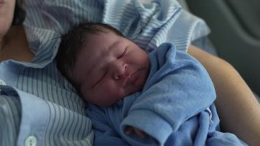Huzurlu yeni doğmuş bebek, ilk gün annesinin kolunda dinleniyor. Huzurlu bebek mahrem günleri doğumdan sonra klinikte.