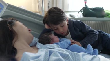 Yenidoğan 'ın İlk Günü Kardeşler tarafından karşılandı - Hastanedeki Otantik Aile Sahnesi, klinikte doğum sonrası annelik sahnesi, kardeşler arasında iç açıcı bir an.