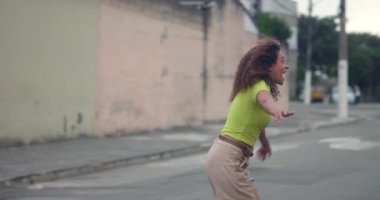 Afrika kökenli anne ve kızı neşeli bir kucaklaşma içinde sessiz bir şehir caddesinde, neşeli ve sevgi dolu bir aile bağını kutluyorlar.