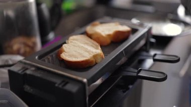 Modern bir mutfağın ızgarasına konmuş iki dilim ekmek, ev yapımı aperatif hazırlama, ev ortamında otantik yemek pişirme ayrıntıları.