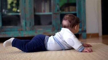 Karnını kaldıran bebek, odaklanmış ifade, oturma odasını keşfetme, emeklemeyi öğrenmenin erken aşamaları, motor beceriler geliştirme, ev ortamı, özenli ve meraklı