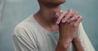 Afrika kökenli Latin kökenli genç, elleri sımsıkı bağlı dua ediyor, imana ve düşüncelere dalmış, açık havada, ruhani adanmışlık, umut, duygusal an.