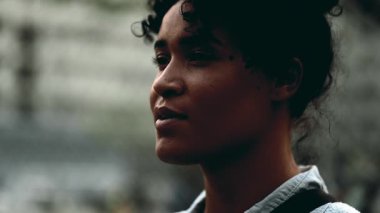 Meditasyon yapan genç siyahi bir kadın gün batımında dışarıda durup derin bir nefes alıyor. Rahatlamaya çalışan düşünceli bir insan.