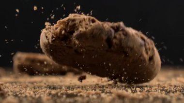 Çikolata parçacıkları masa yüzeyine düşer ve mısır gevrekleri havada çok yavaş bir şekilde makro mercekle 1000 fps hızla uçar.