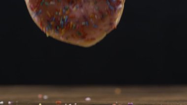 Geniş bir Donut 'ın Masa Üstündeki Suya Düşüşünün Detaylı Yavaş Çekimi, Dokuyu Vurgulamak için Makro Mercek ile Çekildi