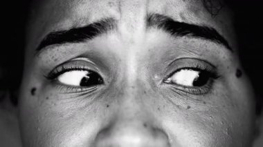 Endişe ve endişeyle yana bakan korkmuş genç bir siyah kadın, 20 'li yaşlarda paranoyak duygular içinde Afrika kökenli bir kadın, siyah ve beyaz.