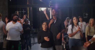 Kilise ortamında grup ibadeti, dua eden, el kaldıran, ruhani bağlantı ve inanç, içeride sadakat ve birliği ifade eden çeşitli gruplar.