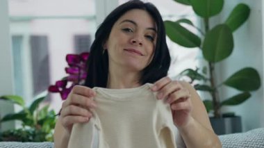 Anne Beklentisi - Hamile Anne Beklentisi Kameraya Bebek Giysileri Gösterme Gururuyla Koltukta Oturma, Gelen Annelik İçin Neşeli ve Heyecanlı