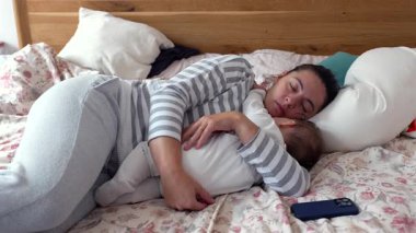 Anne şefkatli bir şekilde bebeğiyle kestiriyor, huzurlu bir bağ kurma anı, huzurlu bir aile bağı, bakım, huzurlu bir aile ortamı, samimi bir aile hayatı.