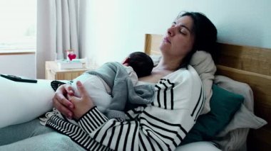 Gözleri Kapalı Yorgun Anne, Yeni Doğan 'ı Yatakta Tutmak - Doğumunun ilk haftasında Sessiz Bir Annelik Anı