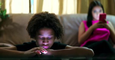 Parlayan akıllı telefon ekranına bakan genç çocuk, dijital içeriğe dalmış, ifadesiz, genç kız telefona dalmış, sosyal medya bağımlılığını aktarıyor ve bağlantıyı kesiyor.