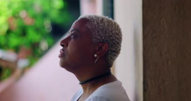 Derin düşüncelere sahip bir kadın, kapalı gözlerle duvara karşı duruyor, duygusal ifade, açık hava düzeni, yakın plan, Afrika kökenli, pişmanlık, sıkıntı, duygusal karmaşa