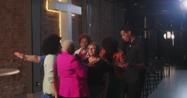 Bir dua buluşmasında kucaklaşan gülümseyen kadınlar, farklı bir inanç topluluğu içinde ruhani bir bağ, şefkat ve birlik anlarını paylaşıyorlar.