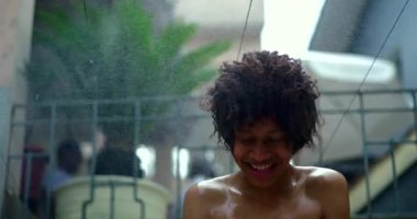 Suyun altında Afrika kökenli neşeli çocuk, hareketli saçlar, mutlulukla parıldayan yüz, kaygısız ve ferahlatıcı anları kucaklayan hayat dolu bir yaz sahnesi.