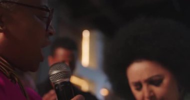 Latin kökenli, Afrikalı bir kadın dua eden bir anda ellerinin rahatlığıyla başka bir kadına sarılıyor, sevgisini, inancını ve bağlantısını iletiyor.