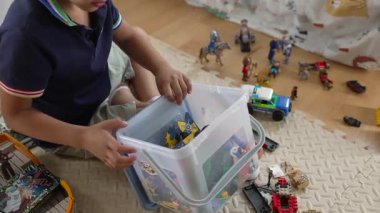 Plastik konteynırdan oyuncak toplayan, yaratıcı oyun oynayan, çocukluk anına odaklanan, yaratıcılık ve eğlence, ev dekorasyonu, ev ortamında rahat oyun zamanı, günlük yaşam.