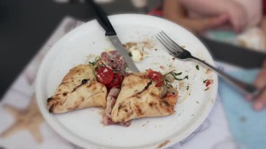 Yarısı yenmiş düz ekmek, domatesler, jambon, çatal ve bıçak yanında sıradan yemek seti, öğle yemeği veya akşam yemeği, tabakta yemek, eksik yemek, gevşetilmiş yemek.