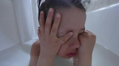 Küvette gözlerini ovuşturan çocuk, yorgunluk ya da tefekkür gösteren, sakin anları ve aile, yaşam tarzı ve ruh sağlığını yansıtan ruh hallerini tasvir etmek için mükemmel.