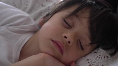 Yatakta huzur içinde uyuyan bir çocuğun çocukluk uykusunun masumiyetini ve sükunetini çocuğun yüzünde yumuşak ve sakin bir ifadeyle yakalıyor.