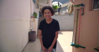 Latin kökenli gülümseyen genç Latin çocuk, banliyöde yaşayan, mutluluk, güven ve iyimserlik saçan, kentsel toplum ortamında neşeli bir kişilik.