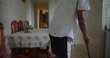 Yaşlı adam sandalyeden kalkar ve kararlılıkla yürür, direnç, bağımsızlık ve sonraki yaşamdaki günlük eylemlerin gücünü gösterir.