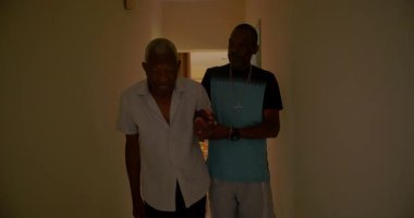 Oğlu, Afrikalı Amerikalı yaşlı babasına mutfağa girmesi ve ona yardım etmesi için yardım ediyor. Yürekten bir bakım, destek ve derin aile bağı.