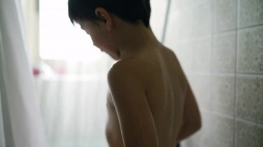Duşta genç bir çocuk, kameradan uzak duruyor, su çağlayarak akıyor, çocukluk günlerini ve günlük rutinlerini kaydediyor.