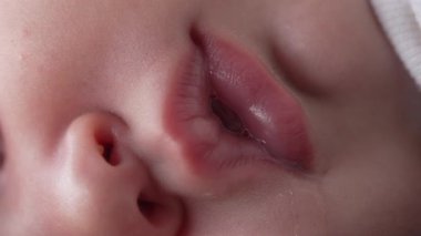Bebek dudakları ve burnu uyurken yakın plan, dudaklarda görünür nem ve göz yaşları, huzurlu uykuyu ve sakinliği vurgulayan samimi detay.