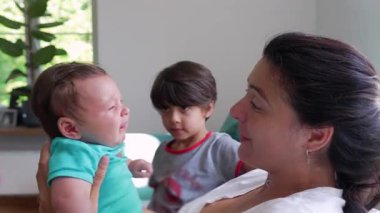 Anne kucağında ağlayan bir bebekle ağlarken ağlayan abim evde şefkatle ve özenle aile içi etkileşimi ve duygularını gösteriyor.