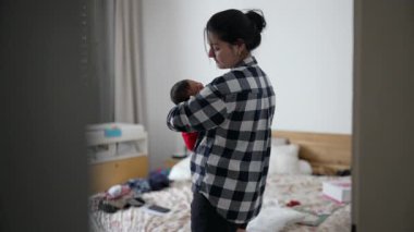 Anne yeni doğmuş bebeği yatak odasında tutuyor, huzurlu bir evde samimi ve sevgi dolu bir bağ kuruyor.