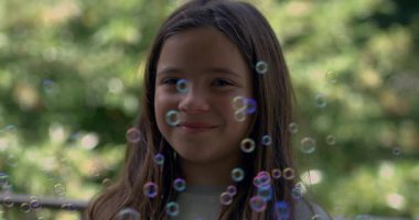 Gülümseyen genç bir kız yavaşça etrafında süzülüyor. 800 fps hızla, açık havada büyülü bir anın tadını çıkarıyor. Bulanık yeşil bir arka planı ve dingin bir atmosferi var.