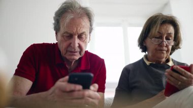 Akıllı telefonları kullanan yaşlı bir çift, dijital uygulamaları, modern teknolojiyi, son sınıf yaşam tarzını, yeni beceriler öğrenmeyi, bağlı kalmayı, gündelik ortamları, odaklanmayı ve etkileşimi keşfediyor.