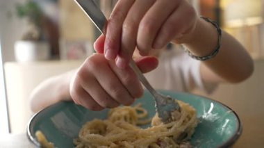 Çocuk yemek saatinde spagetti yiyor, 5 yaşında karbonhidrat zengini bir çocuğun yakın plan yüzü.