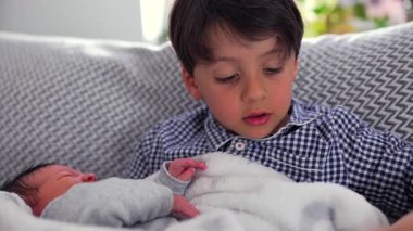 Ağabey, kucağında küçük kardeşiyle kucak kucağa yatarken ikisi de şefkatli bakışlar atıyor. Bu da güçlü bir kardeş bağının ve çocukluğunda aile sevgisinin sıcaklığını simgeliyor..