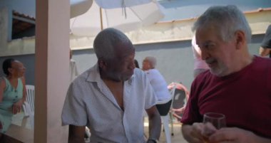 İki yaşlı arkadaş arka bahçedeki bir barbekü partisinde kahkaha ve içki paylaşıyor. Canlı ve neşeli bir açık hava buluşması sırasında arkadaşlığın ve bağlantının keyfini çıkarıyorlar.