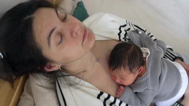 Bebeklerin ilk haftasında uyuyan yorgun anne ve yeni doğan bebek yorgun bir ebeveynin insan hayatının ilk günlerinde enerjisini geri kazanması, şekerleme zamanı..