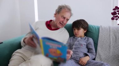 Büyükbaba, genç torununa renkli bir çocuk kitabı okurken rahat bir kanepede oturuyordu. İkisi de hikâyede derinden bağlıydılar. Aile bağlarını kuvvetlendiren bir andı..
