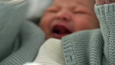 Yeni doğan bebek yumuşak bir battaniyeye sarılmış, ağlamaya başlıyor, erken yaşlarda duygusal bir sıkıntı anı yakalıyor, sıcak ve güvenli bir ortamda yuva yapıyor..