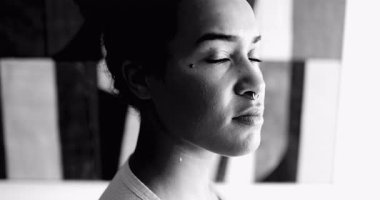 Afro-Amerikan genç kadın dramatik siyah-beyaz portre ciddi bir ifadeyle kameraya bakıyor. 20 'li yaşlardaki yetişkin bir kız tek renk konusunda kendini güçlü hissediyor.