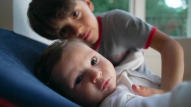 Ağabeyi bebeği kucaklıyor, hassas kardeş bağı, koruyucu jest, çocukluk arkadaşlığı, sevgi, ilgi, bağ, yakınlık, aile sıcaklığı, yuva kurma