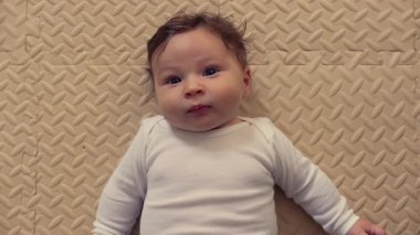 Bebek mindere uzanıyor, neşeyle gülüyor, gülümsüyor, neşeli ifade, neşeli ruh hali, çocukluk mutluluğu, rahat bir yuva kuruyor, rahat ve rahat.