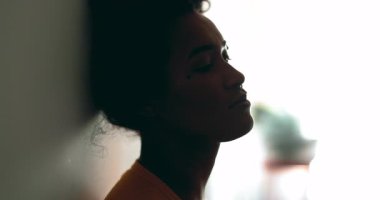 Depresyondaki siyah Latin bir kadın, melankolik bir ifadeyle duvara yaslanıyor. Mesafeye bakıyor. Düşüncelere dalıp gidiyor.