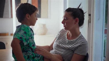 Anne, genç oğlanı şefkatle kucaklıyor, şefkatli aile anı, sıcak kucaklaşma, derin duygusal bağ, sevgi ve ilgi, destekleyici anne-oğul ilişkisi, ev içi samimi ortam.