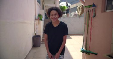 Latin kökenli gülümseyen genç Latin çocuk, banliyöde yaşayan, mutluluk, güven ve iyimserlik saçan, kentsel toplum ortamında neşeli bir kişilik.