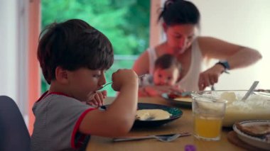 Aile yemeği, anne aynı anda birden fazla iş yaparken, büyük çocuk bağımsız yemek yer, ev yemeği, yetiştirme ortamı, ebeveynlerin bakımı ve yemek zamanını dengeler.