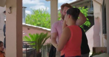 Bir erkek, sıcak ve sıradan bir kutlamada neşeli arkadaşları ve akrabaları tarafından çevrelenmiş açık hava aile toplantısı sırasında bir kadına hayat dolu bir dansa liderlik ediyor.