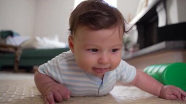 Bebek karın üstü, baş kaldırma, çevreyi keşfetme, erken motor beceriler, merak, bebek gelişimi, güç eğitimi, çocukluk dönüm noktası, odaklanmış ifade, büyüme